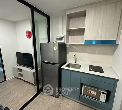Modern compact kitchen with sleek appliances and open layout in a stylish apartment.