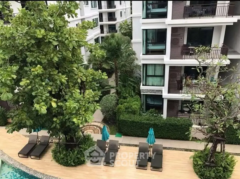 Luxurious condominium with poolside view and lush greenery, perfect for relaxation and modern living.