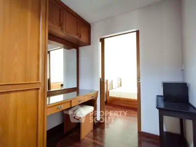 Cozy bedroom with wooden furniture and study desk, perfect for relaxation and work.