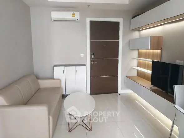 Modern living room with sleek furniture and built-in TV unit in a stylish apartment.