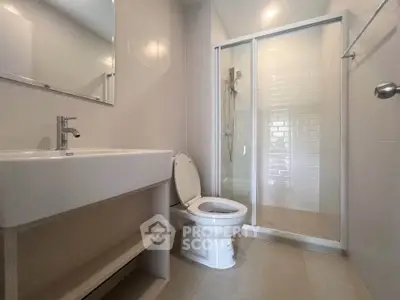 Modern bathroom with sleek shower and contemporary fixtures in a stylish real estate property.