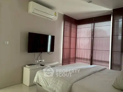 Modern bedroom with air conditioning and wall-mounted TV, featuring sleek design and natural light.