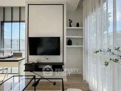 Modern living room with sleek TV setup and large windows