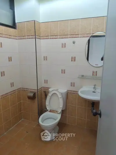 Cozy bathroom with tiled walls and modern fixtures, perfect for a compact living space.