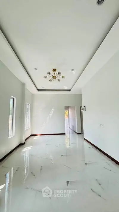 Spacious modern living room with elegant ceiling light and glossy marble flooring
