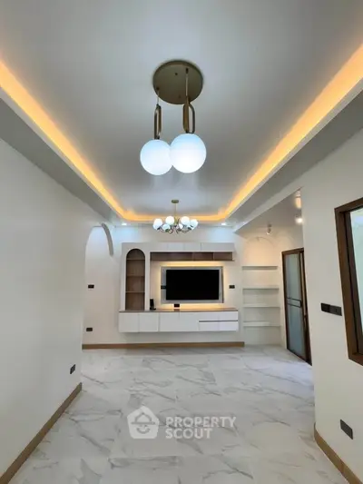 Modern living room with elegant lighting and built-in entertainment center.