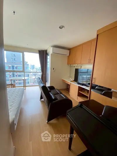 Modern living room with city view, featuring sleek furniture and built-in storage.