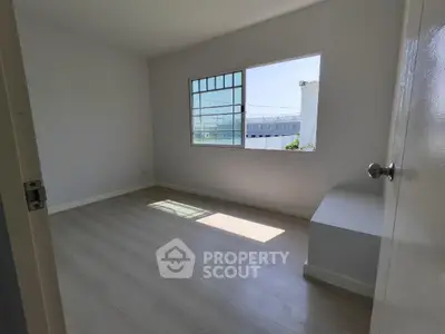 Bright empty bedroom with large window and modern flooring