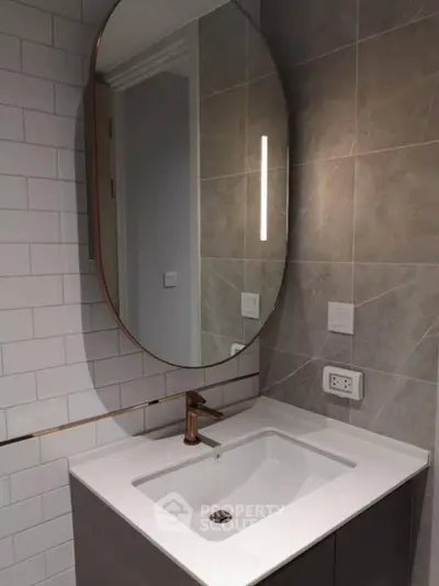 Modern bathroom with elegant oval mirror and sleek sink design
