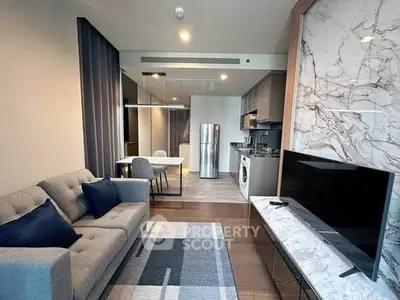 Modern living room with open kitchen, featuring sleek furniture and stylish decor.