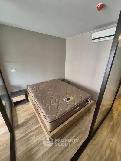 Modern bedroom with minimalist design featuring a comfortable bed and sleek glass partitions.