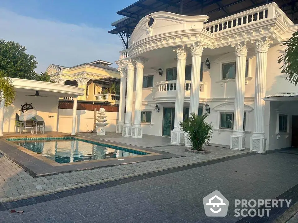 Luxurious villa with elegant columns and private pool in a serene neighborhood.