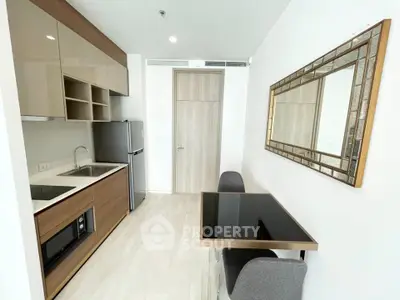 Modern kitchen with sleek cabinetry and dining area in stylish apartment