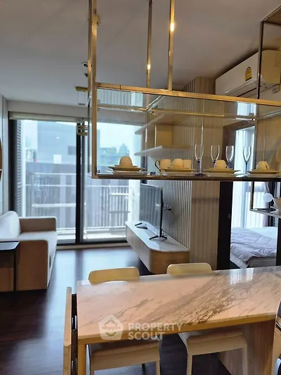 Modern open-plan living room with stylish dining area and large windows in a contemporary apartment.
