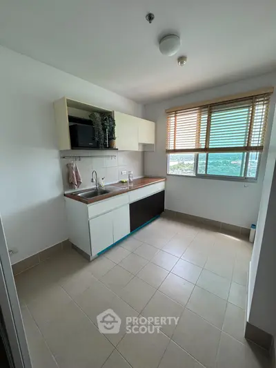 Modern kitchen with large window and sleek cabinetry, offering a bright and airy atmosphere.