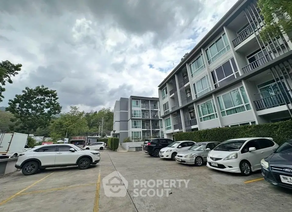 Modern apartment building with parking area and lush greenery