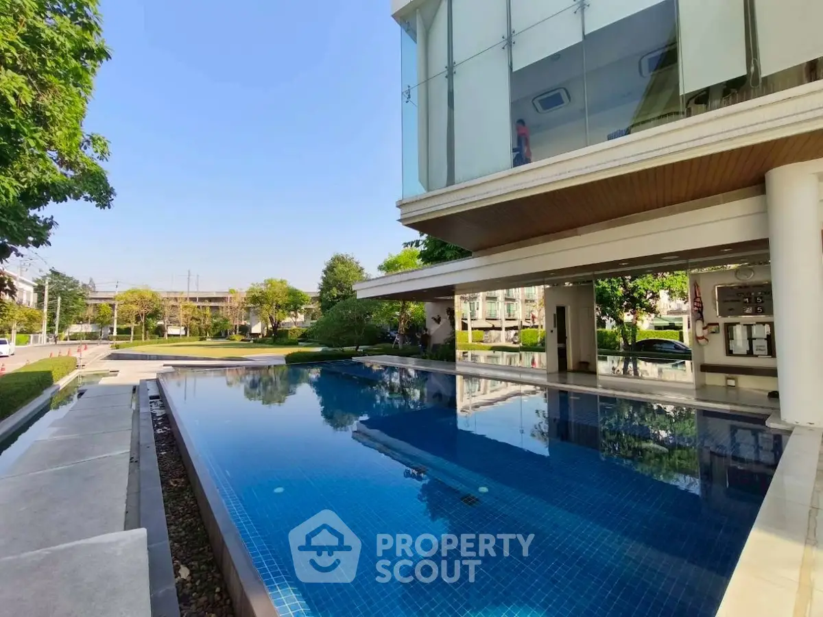Luxurious modern building with stunning outdoor pool and lush greenery.