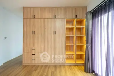 Spacious bedroom with elegant wooden wardrobe and natural light