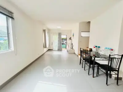 Spacious living room with dining area and large windows for natural light