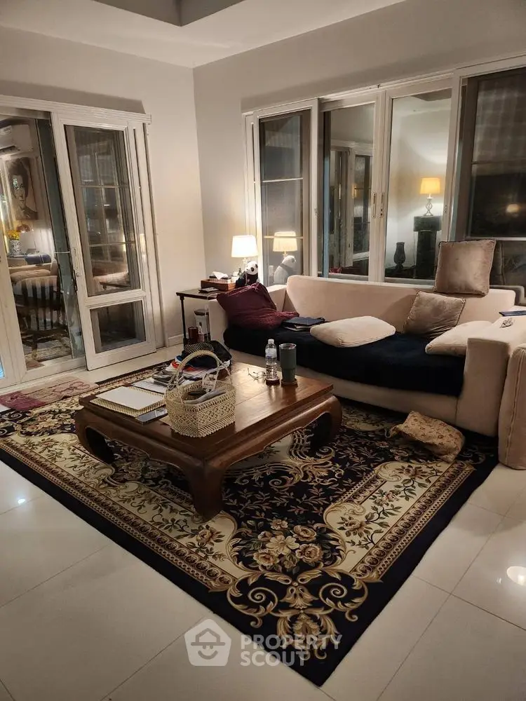 Elegant living room with plush sofa and ornate rug, perfect for relaxation and entertaining.