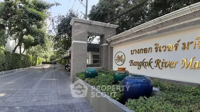 Elegant entrance of Bangkok River Marina with lush greenery and stylish signage.