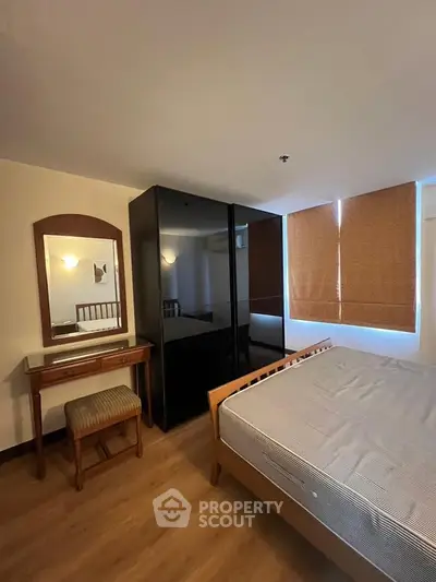Spacious bedroom with modern wardrobe and cozy wooden furniture, perfect for relaxation.