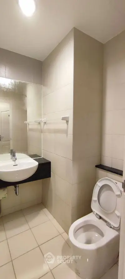 Modern bathroom with sleek design and white fixtures in a contemporary apartment.