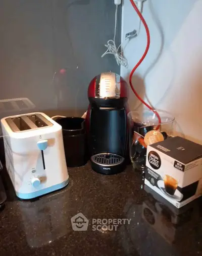 Modern kitchen corner with coffee machine and toaster on sleek countertop.