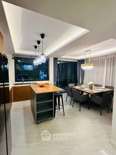 Modern kitchen and dining area with elegant lighting and open layout