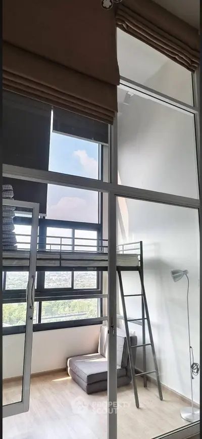 Modern loft apartment with high ceilings, large windows, and a cozy mezzanine bed area.