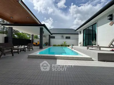 Luxurious modern home with private pool and spacious outdoor patio under a clear blue sky.