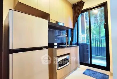Modern kitchen with sleek appliances and balcony view in a stylish apartment.