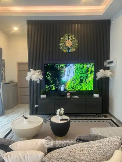 Luxurious living room with modern decor, large TV, and elegant furnishings, perfect for relaxation and entertainment.