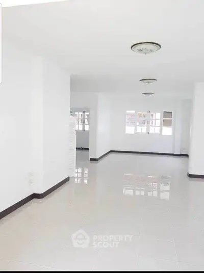 Spacious white interior with glossy tiled floors and ample natural light.