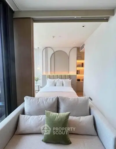 Modern bedroom with stylish decor and cozy seating area, perfect for relaxation.