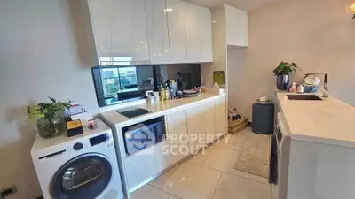 Modern kitchen with sleek white cabinets, built-in appliances, and stylish decor.