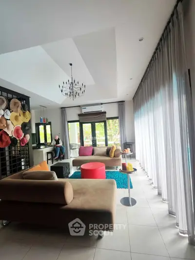 Stylish living room with modern decor, large windows, and cozy seating area.