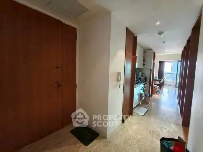 Spacious apartment hallway with modern kitchen and balcony view.