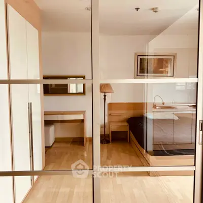 Modern bedroom with glass sliding doors and stylish wooden furniture
