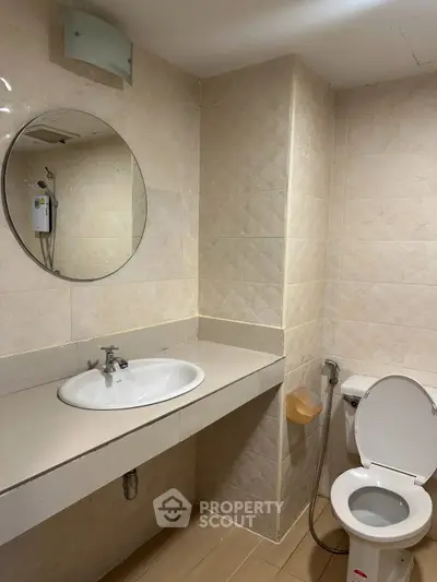 Modern bathroom with round mirror and sleek fixtures in a contemporary home.