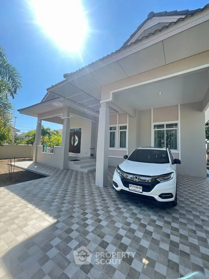 Charming modern house with spacious driveway and sleek car parked under sunny skies.