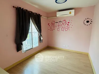 Charming empty bedroom with pink walls and air conditioning, perfect for personalization.