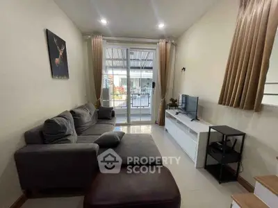 Cozy living room with modern decor and large sliding glass doors leading to balcony.