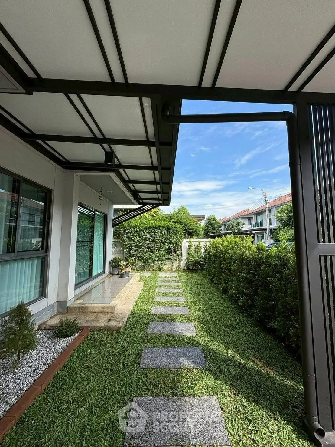 Charming garden pathway leading to modern home with lush greenery and stylish design.