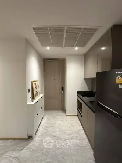Modern kitchen with sleek cabinetry and stainless steel appliances in a stylish apartment.