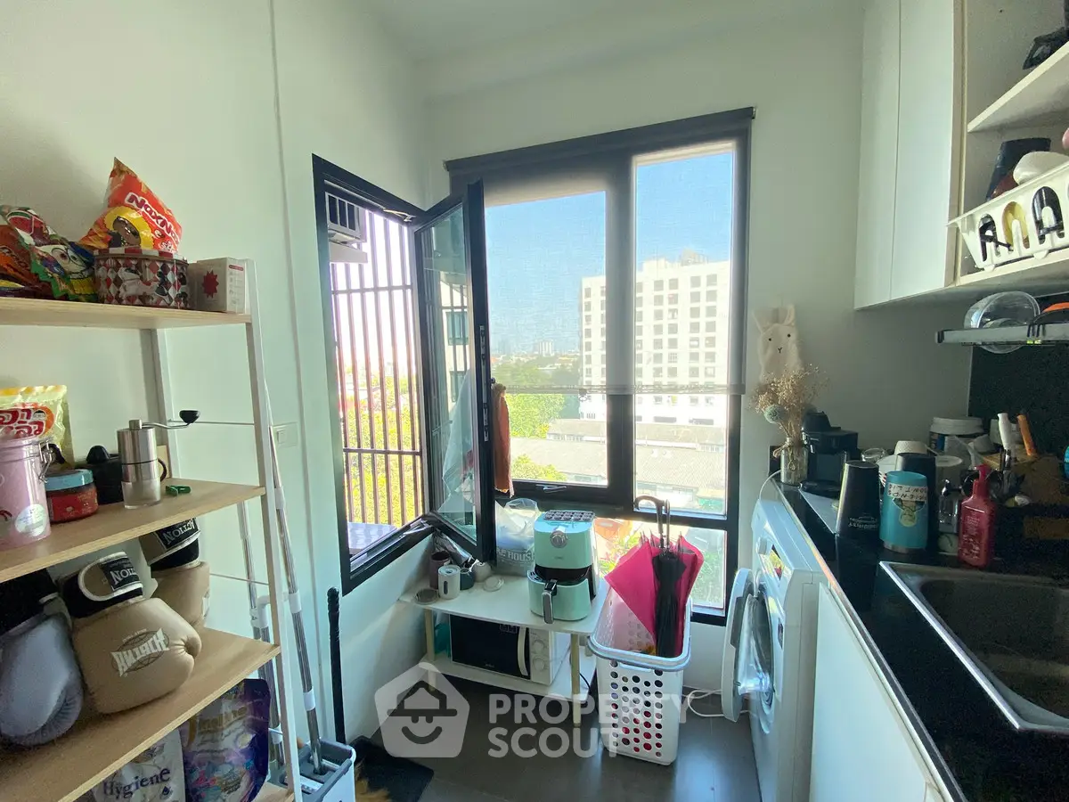 Compact kitchen with city view, featuring modern appliances and ample storage space.