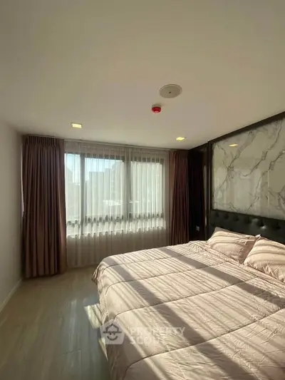 Bright and cozy bedroom with large window and elegant decor in modern apartment.