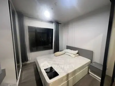 Modern bedroom with large window and minimalist decor, featuring a comfortable bed and sleek flooring.