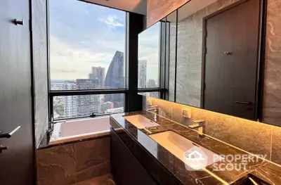 Luxurious bathroom with city view, featuring dual sinks and a bathtub by the window.