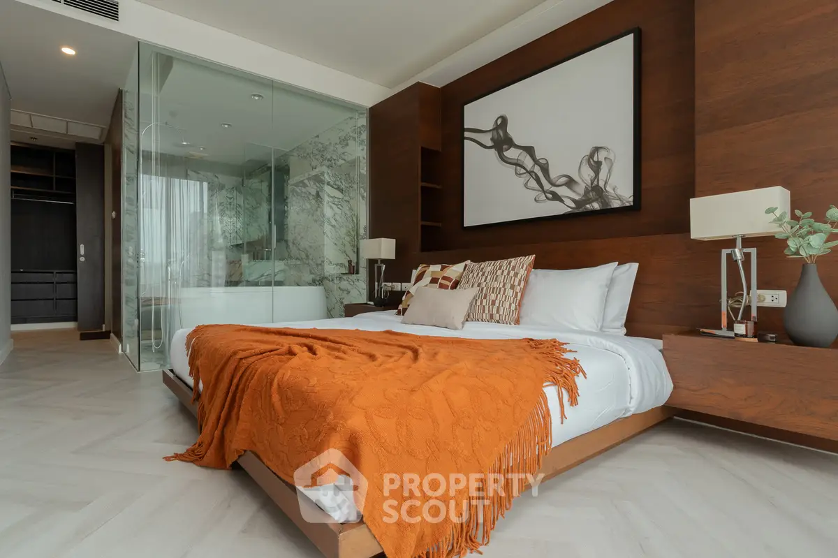 Luxurious bedroom with modern glass-enclosed bathroom and elegant decor